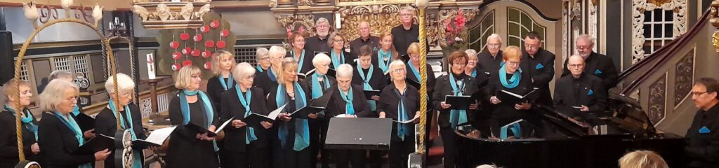 Gemischte Chor der Liedertafel Elmshorn. Bei der Musik zur Marktzeit 2024 entstand eine Aufnahme der Chormitglieder in einheitlicher Kleidung, schwarz mit blauem Schal.