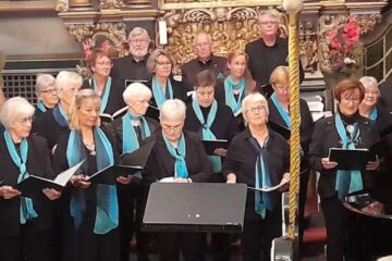 Gemischte Chor der Liedertafel Elmshorn. Bei der Musik zur Marktzeit 2024 entstand eine Aufnahme der Chormitglieder in einheitlicher Kleidung, schwarz mit blauem Schal.